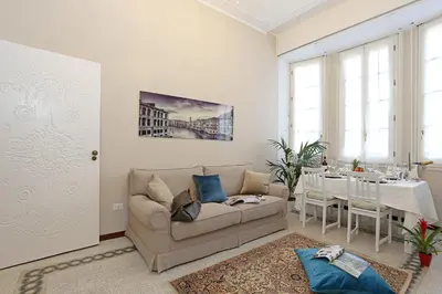 a living room with a couch and a table at Liberty Rome Apartment - Liberty Collection in Rome