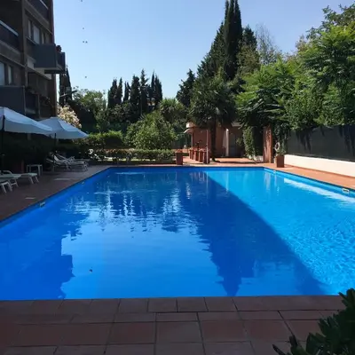 a large blue swimming pool in a building at Megi San Peter Apartment in Rome