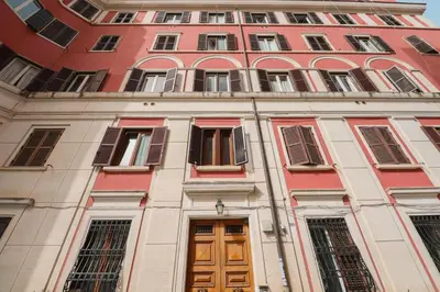 a tall red building with doors and windows at Labicana Apartment in Rome