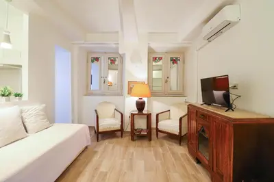 a living room with a bed and a tv at Labicana Apartment in Rome