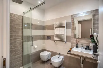 a bathroom with a toilet and a sink and a shower at Borgognona Rooms in Rome