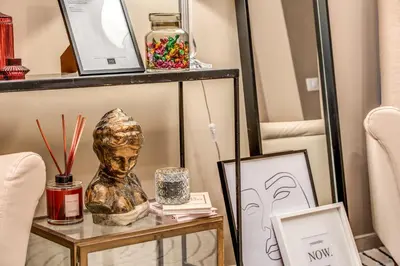 a table with a bust on it next to two chairs at Borgognona Rooms in Rome