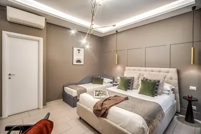 a bedroom with two beds and a couch at Borgognona Rooms in Rome