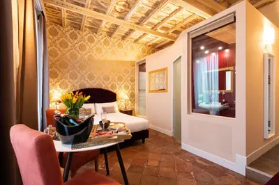 a hotel room with a bed and a table with flowers at Le Suite del Barone in Rome