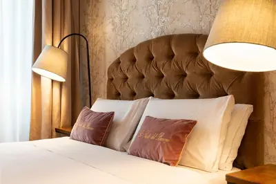 a bedroom with a bed with two pillows and two lamps at Le Suite del Barone in Rome