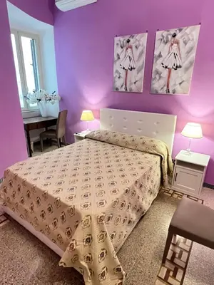 a bedroom with a bed and a purple wall at Guest House Biondi in Rome