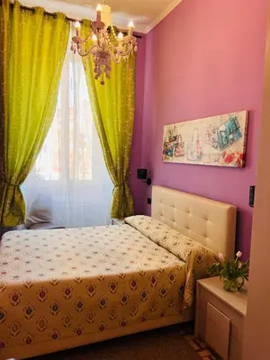 a bedroom with purple and green curtains and a bed at Guest House Biondi in Rome