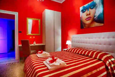 a red bedroom with a bed with towels on it at Guest House Biondi in Rome