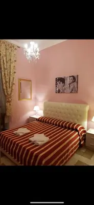 a bedroom with a bed with a striped blanket at Guest House Biondi in Rome