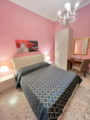 a bedroom with a bed and a pink wall at Guest House Biondi in Rome