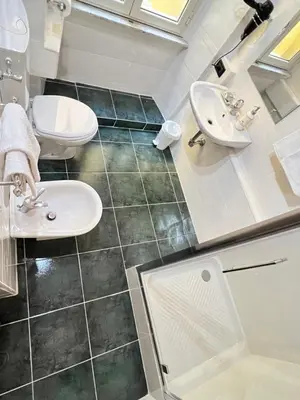 a bathroom with a sink and a toilet and a mirror at Guest House Biondi in Rome