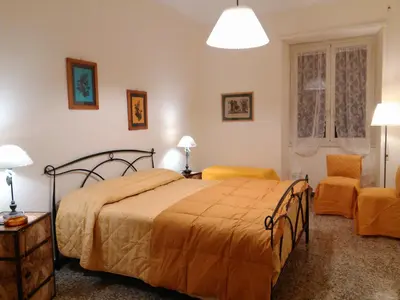 a bedroom with a bed and two orange chairs at Il Vostro Comfort in Rome