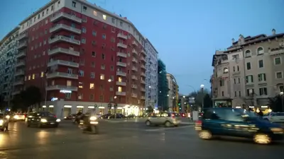 a busy city street at night with cars and buildings at Il Vostro Comfort in Rome