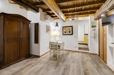 a living room with a table and a chair at Pellegrino Campo de' Fiori Suite in Rome