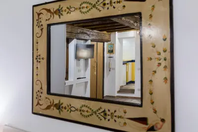 a mirror on a wall with flowers on it at Pellegrino Campo de' Fiori Suite in Rome