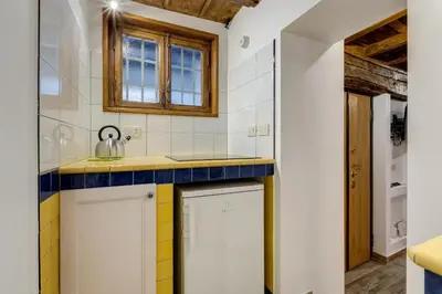 a kitchen with white cabinets and a blue counter top at Pellegrino Campo de' Fiori Suite in Rome