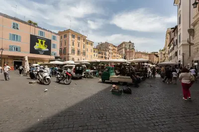 a group of people walking around a market in a city at Pellegrino Campo de' Fiori Suite in Rome