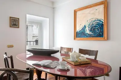 a dining room with a table and a painting on the wall at The Pantheon view in the heart of Rome in Rome