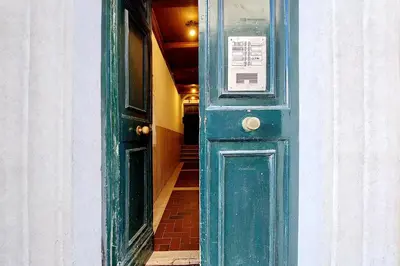 a green door with a sign on it in a hallway at The Pantheon view in the heart of Rome in Rome