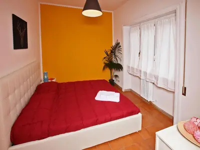 a red bed in a room with a window at Alice Home in Rome