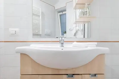 a white bathroom with a sink and a mirror at Coronari stylish apartment in Rome