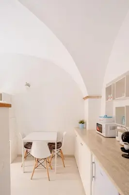 a white kitchen with a table and chairs at Coronari stylish apartment in Rome