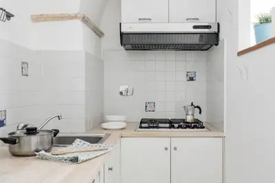 a white kitchen with a sink and a stove at Coronari stylish apartment in Rome