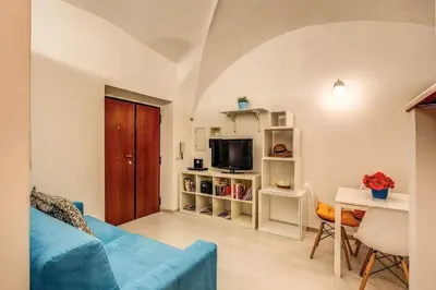 a living room with a blue couch and a tv at Coronari stylish apartment in Rome