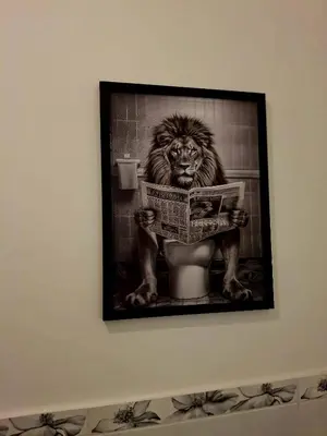 a picture of a lion reading a newspaper in a bathroom at Double B Ferruccio I in Rome
