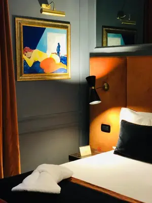 a bedroom with a bed and a painting on the wall at Saint B Boutique Hotel STB in Rome
