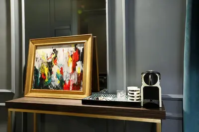 a framed painting on a table with a coffee maker at Saint B Boutique Hotel STB in Rome