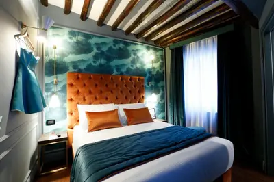 a bedroom with a large bed and a painting on the wall at Saint B Boutique Hotel STB in Rome