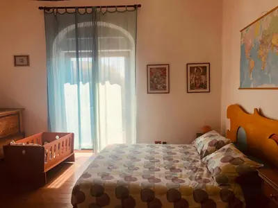 a bedroom with a crib and a large window at San Saba Rooftop Garden in Rome