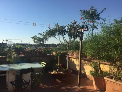a patio with a table and a tree on a balcony at San Saba Rooftop Garden in Rome