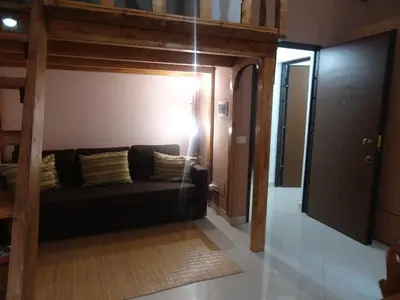a living room with a black couch in a room at 1A Grace House in Rome