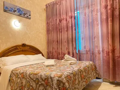 a bedroom with a bed and a curtain with towels on it at Botel Inn in Rome