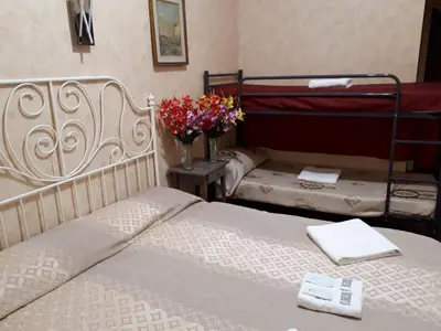 a bedroom with a bed and two bunk beds with flowers at Botel Inn in Rome