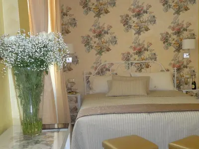 a mirror with a painting of flowers on a wall at Cameo B&B in Rome