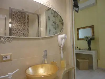 a vase of flowers on a table with a mirror at Cameo B&B in Rome