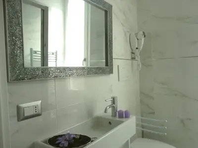 a white bathroom with a sink and a mirror at Cameo B&B in Rome