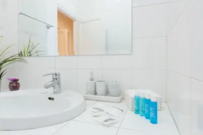 a white bathroom with a sink and a mirror at Domus Mari in Rome