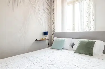 a bedroom with a white bed with green pillows at Domus Mari in Rome