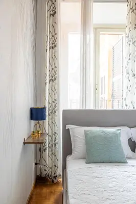 a white bedroom with a bed and a window at Domus Mari in Rome