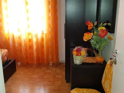 a room with a black cabinet with a vase of flowers at Domina Romae B&B in Rome