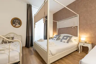a bedroom with a white bed with a canopy bed at Popolo Rooms&Suites in Rome