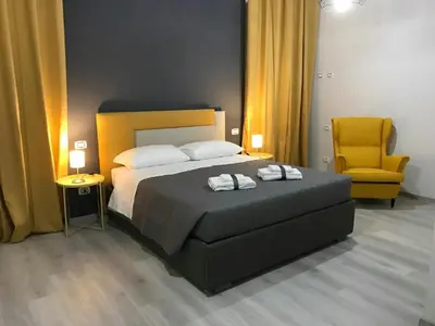 a bedroom with a bed and a yellow chair at Sensation House in Rome