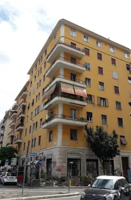 a yellow building with cars parked in front of it at Blue Star luxury apartment San Giovanni - Colosseo in Rome