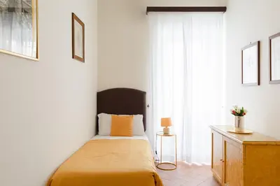 a bedroom with a bed with yellow sheets and a window at Relais Rasella 47 in Rome