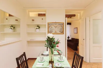 a dining room with a table with a vase of flowers at Relais Rasella 47 in Rome