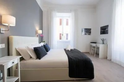 a bedroom with a large bed and a desk in it at Le Stanze Di Gaia in Rome